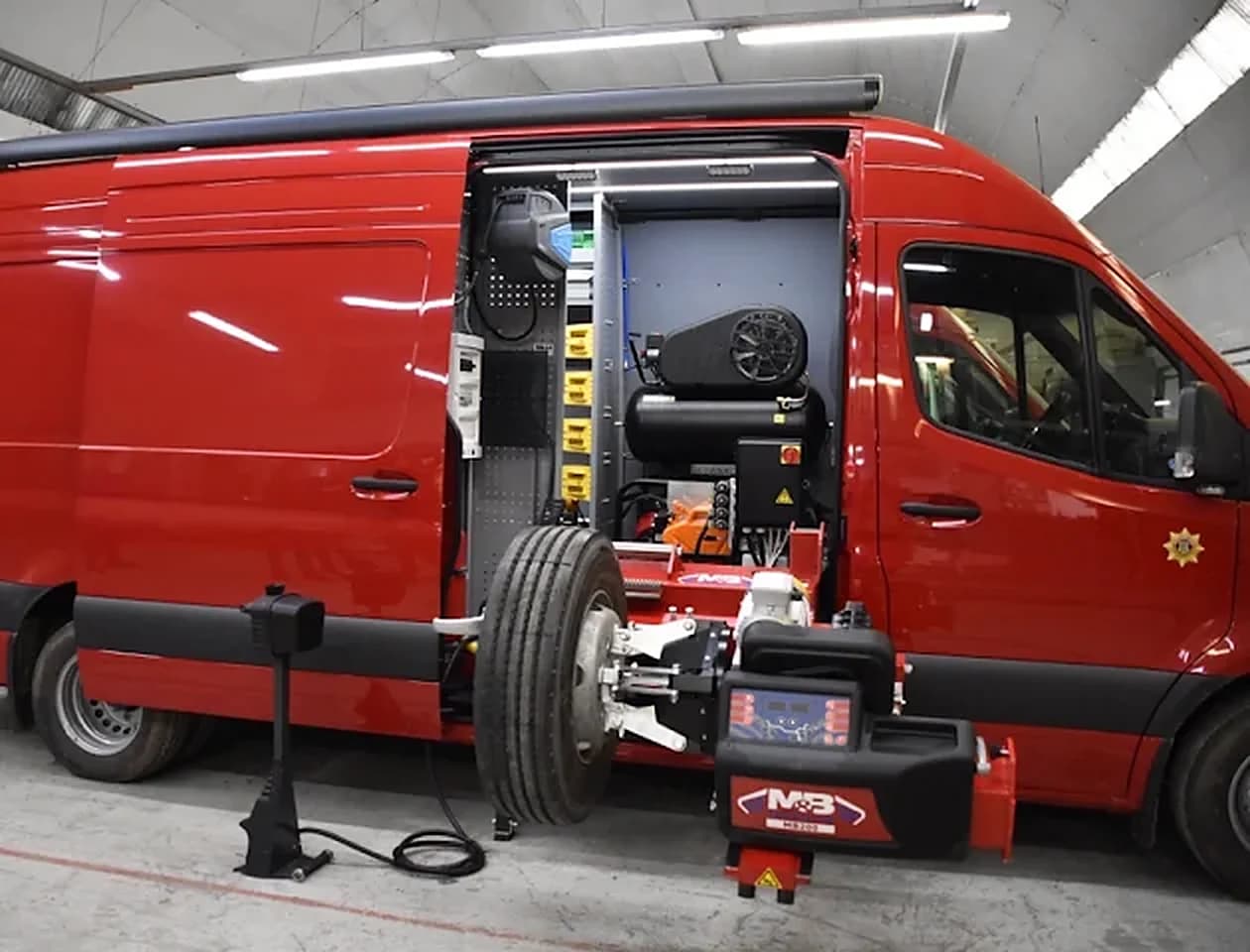 Servicebus met de bandenmontagemachine en de compressor